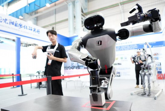 9月5日，在沈陽的2025全球工業(yè)互聯(lián)網(wǎng)大會的展覽區(qū)現(xiàn)場，中國科學(xué)院沈陽自動(dòng)化研究所的機(jī)器人工程師在調(diào)試具身智能操作系統(tǒng)。新華社記者 李鋼 攝