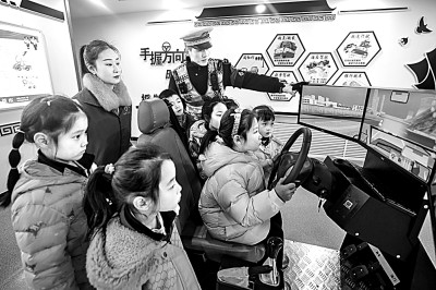 山東省榮成市公安局道路交通安全宣傳教育基地，交警帶領(lǐng)小學(xué)生現(xiàn)場體驗?zāi)M駕駛。新華社發(fā)